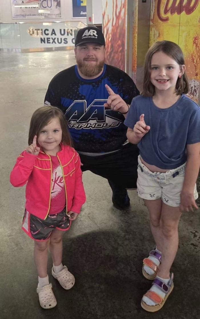 Jamie Graham posing with two young fans
