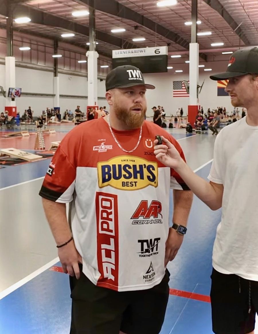 Jamie Graham being interviewed courtside, jersey with sponsor logos clearly visible